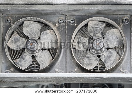 Two industrial cooling fans covered with dirt and dust