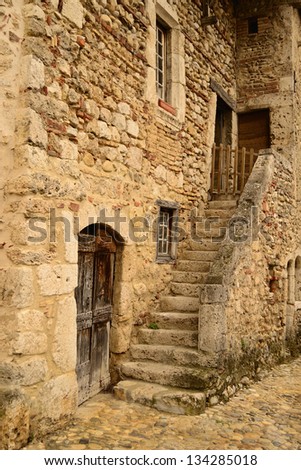 Antique house, door and stairs in a cobbled street. Close-up of Perouges, a medieval village in France