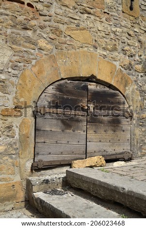 Medieval and wooden door, stone wall and stairs