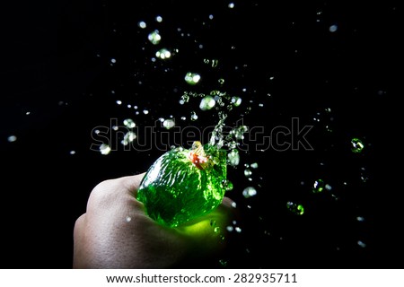 Stop motion of squeezing green liquid from plastic bag.