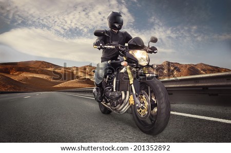 Man seat on the motorcycle on the desert road