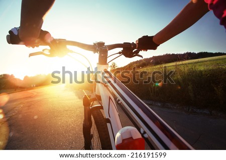 Hands in gloves holding handlebar of a bicycle