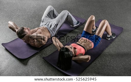 athletic woman and man working ab intervals in fitness
