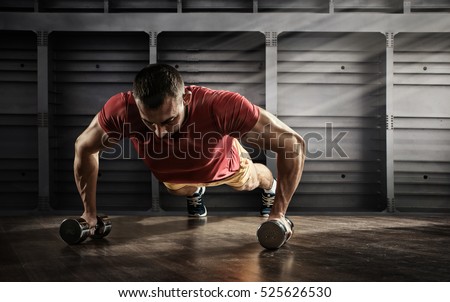 Sport. Handsome man doing push ups exercise with one hand in fitness gym