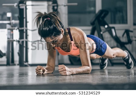 Muscular woman on a plank position.