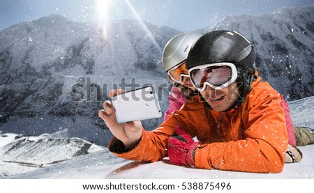 Sport and travel backgrounds. Winter, ski, snow and fun - family enjoying ski holiday. Mobile photo. Selfy.