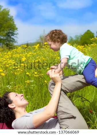 The joy and sweetness on seeing a mother and her son playing among the flowers in a park.