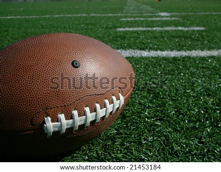Football on hash marks of high school turf football field
