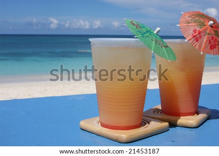 Cold beverages on coasters at beach front of island resort
