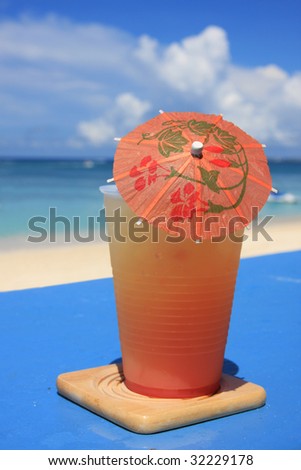 Orange drink umbrella against background distant sky.