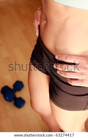 Midsection of woman post workout with hands on hip