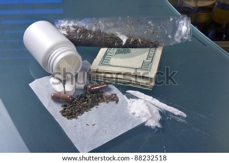 pill bottle with marijuana, cocaine, weed and drug money on a glass table