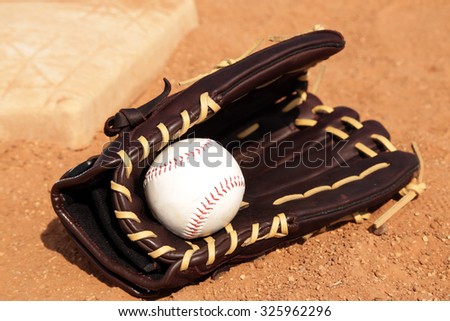 Baseball equipment on the field, with glove base and ball