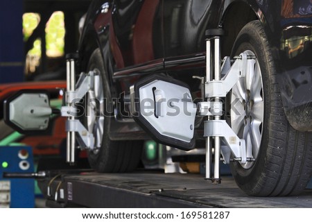 Car wheel fixed with computerized wheel alignment machine clamp.