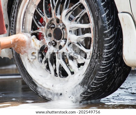 Outdoor tire car wash with sponge.