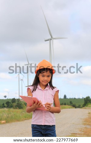 Girl engineer or architect with white safety hat and wind turbines on background.