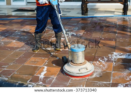 People cleaning floor with machine