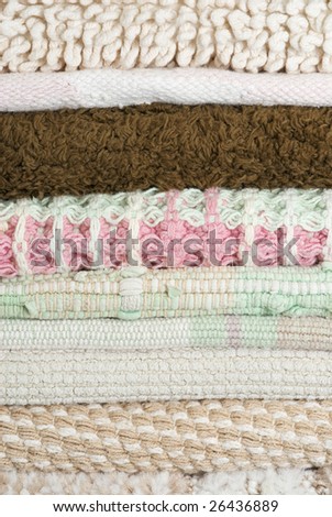 Stack of woven fabric throw rugs background texture