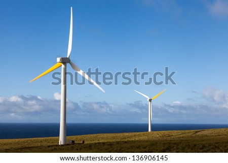 Two wind generators produce renewable energy overlooking Pacific Ocean