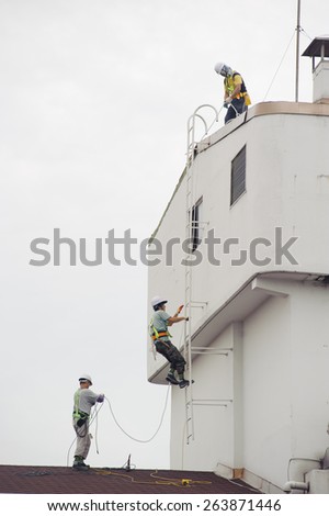 SEOUL, KOREA - SEPTEMBER 6, 2010: Roofers reparing the roof at the top of a general apartment in Seoul, Korea.