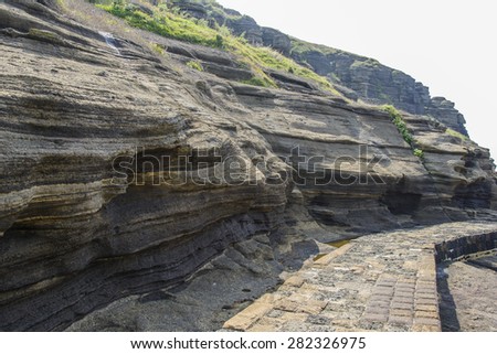 Multistory layered rough and strange sedimentary rocks in famous tourist site Yongmeori Coast(Dragon head coast) in Jeju Island, Korea.