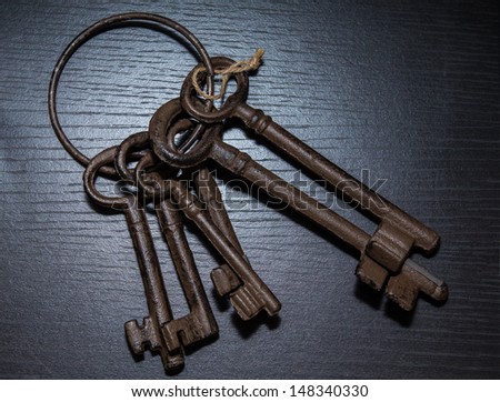 6 antique keys on wooden table.