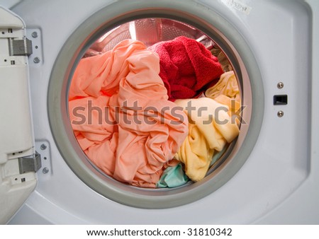 washing machine drum full with dirty laundry