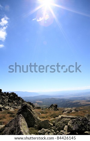 mountain view peak with rocks blue sky and sun