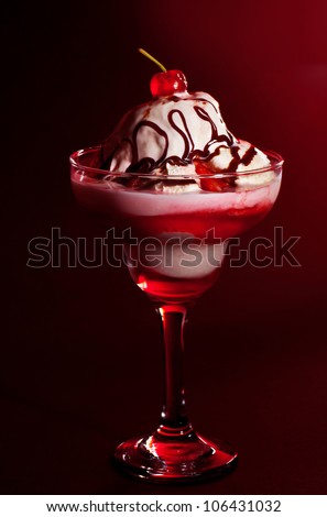 Cold fruity ice cream, tasty vanilla frozen yogurt still life isolated on red background, cherry jam and liquid chocolate topping, sundae in the glass, sweet food styling, decorated design dessert