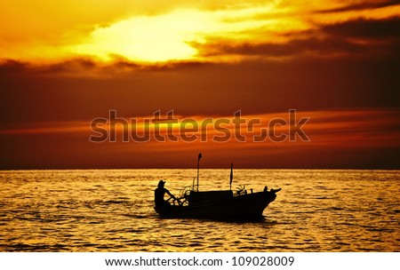 Fisherman on the boat over dramatic sunset, male on vessel, beautiful seascape with dark clouds, ship silhouette in ocean over evening sunlight, traveling, holiday, vacation and hobby conception