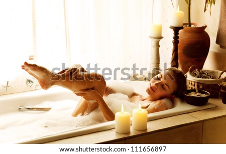 Photo Of A Woman Relaxed At Luxury Spa Salon, Picture Of Young Beautiful Lady Taking Bath At Home, Image Of Pretty Female Bathing With Soap Foam And Candles In Hotel Room, Cute Girl Relax In Jacuzzi
