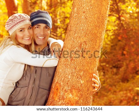 Picture of happy people spending fun time together in beautiful autumn park, closeup portrait of attractive female and handsome male smiling, young adult couple enjoying outdoor, love concept