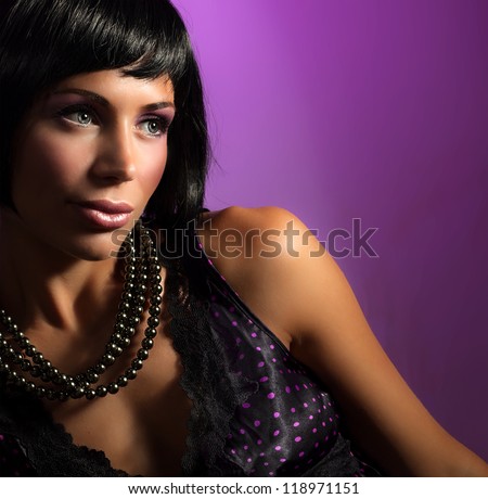 Image of gorgeous woman wearing glamorous necklace, closeup portrait of cute female in luxury jewelry isolated on purple background, young lady with stylish makeup and hairstyle, beauty concept