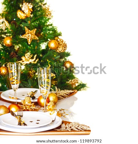 Photo of Christmastime table setting border, beautiful decorated Christmas tree isolated on white background, romantic holiday dinner, luxury white dishware decorated with golden ribbon