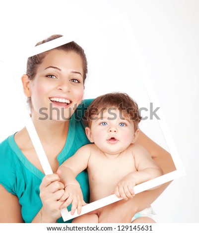 Photo of beautiful young mother with cute baby boy holding white frame, closeup portrait of attractive female with sweet infant isolated on white background, adorable child, happiness and love concept
