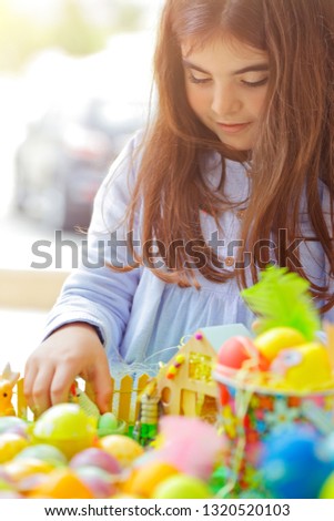 Portrait of a sweet little baby girl having fun on Easter holiday celebration, making Easter crafts, happy religious holiday
