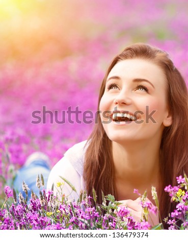 Closeup Portrait Of Beautiful Female Laying Down In Fresh Pink Floral Field, Warm Sunset Light, Spring Nature, Vacation And Leisure Concept
