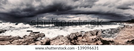 Landscape of storm on the sea, dark cloudy sky, rocky seashore, hurricane in the ocean, rainstorm, wind power, bad weather concept
