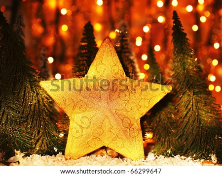 Christmas tree star decoration with winter ornament as holiday background over abstract defocus golden lights