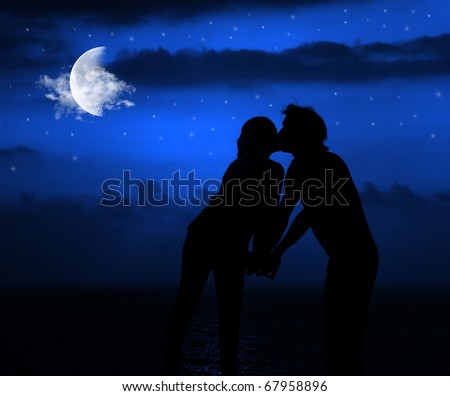 Happy couple romantically kissing at night under moonlight