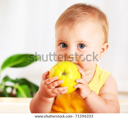Little baby eating apple, closeup portrait, concept of health care & healthy child nutrition