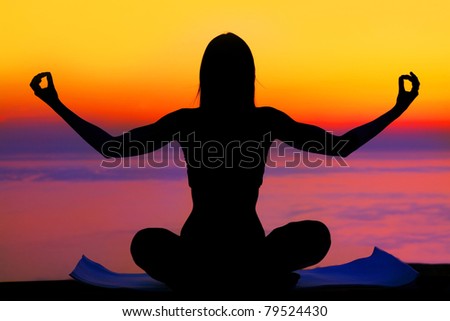 Healthy woman doing yoga outdoor, sunset over sea, body care & meditation concept