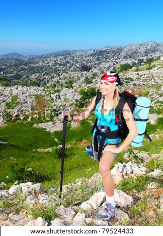 Traveling girl with backpack hiking in the mountains, eco tourism