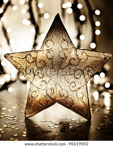 Star, Christmas tree ornament, golden decoration over blur lights, dark new Year eve background, winter holidays home decor