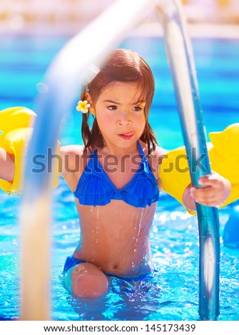 Little girl move out of the pool, having fun in water, summer vacation, beach resort, enjoying time in daycare, active childhood concept