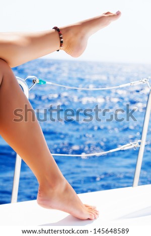 Closeup on beautiful sexy women\'s feet on the yacht, body part, journey on sailboat, summer vacation, conceptual image of pleasure and enjoyment