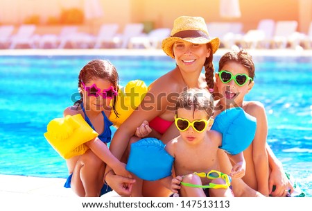 Happy big family having fun at the pool, spending summer vacation together, wearing funny colorful sunglasses, enjoyment and pleasure concept