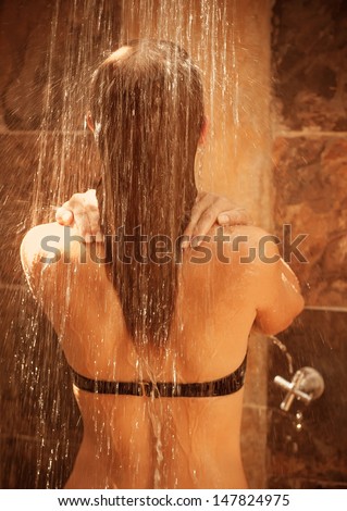 Back side of cute blond girl take shower outdoor in sunny day, enjoying water splash, relaxation on spa resort, people hygiene conception