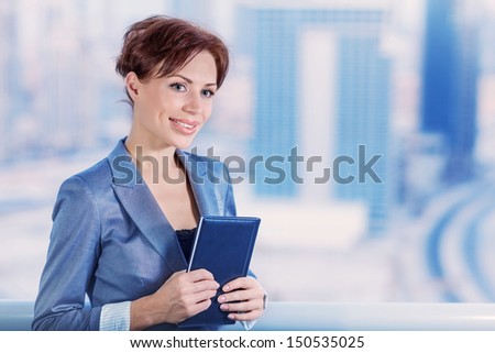 Portrait of beautiful secretary on modern building background, VP of big corporate, successful female with notebook, wearing elegant suit, business concept