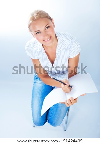 Beautiful blond school girl sitting on chair and write test, looking up, isolated on white background, going to university, knowledge concept